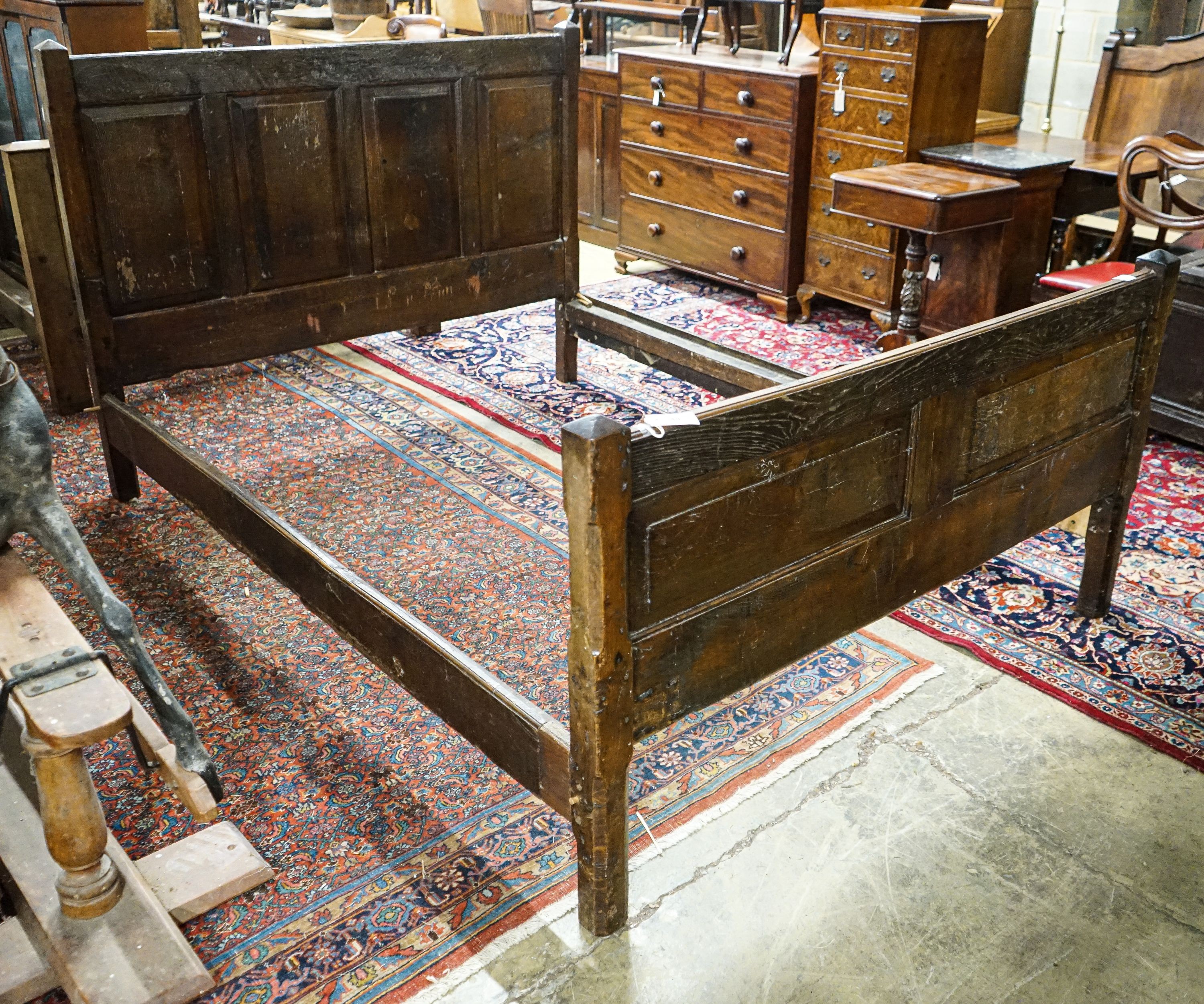 A 17th century style panelled oak bedstead, width 158cm, length 208cm